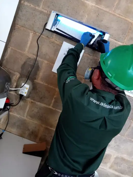 Técnico da Detecta fazendo manutenção de armadilha luminosa SIMP
